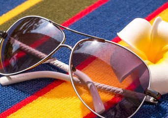 Sunglasses On Towel Shows Sunny Exotic Holiday