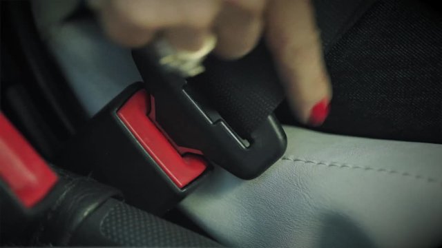woman fasting seat belt in a car