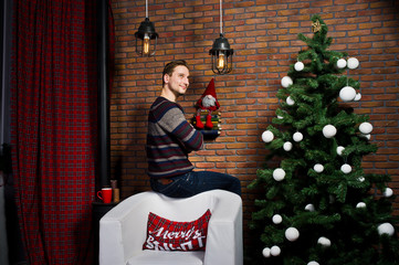 Studio portrait of man against christmass tree with decorations.