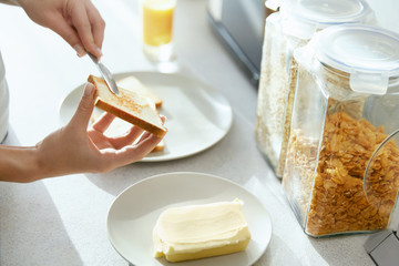 Woman Hands Applying Butter On Bread.