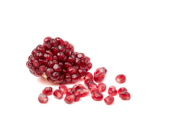 Red ripe pomegranate grains on white background.