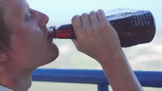 Drunk man drinking wine from the bottle. Close up. slow motion. 3840x2160