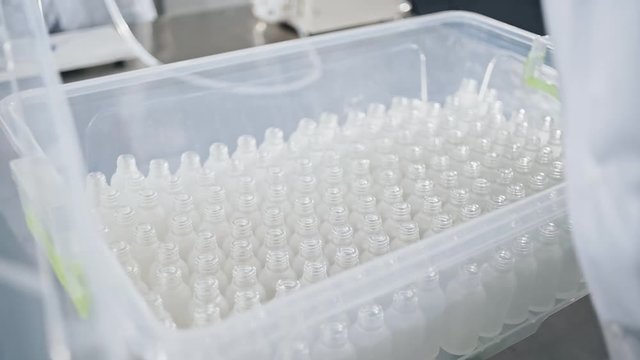 Set of test tubes close-up in laboratory assistant hands in plastic box.