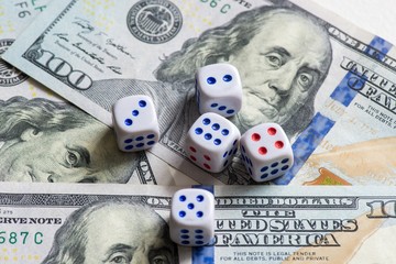 White dice are on a dollar bill of US dollars. The concept of gambling with rates in monetary units