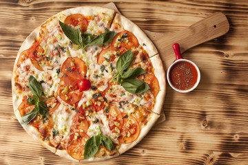 Vegetarian pizza with bassil on wooden board served with ketchup