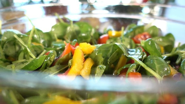 Spinach salad with tomatoes and bell pepper close up, rotating, 4K