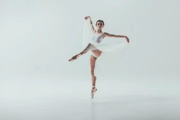 Foto op Aluminium young elegant ballerina dancing in studio, isolated on white © LIGHTFIELD STUDIOS