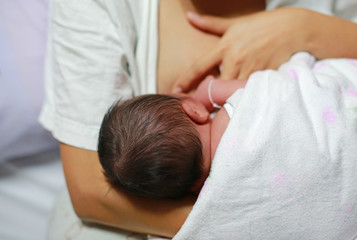 Young mother breast feeding her newborn child.