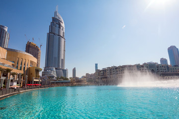 Downtown Dubai skyline, view from the Dubai fountain. Modern city cityscape with skyscrapers, sidewalk with perspective in sunny day.
