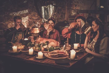 Fotobehang Medieval people eat and drink in ancient castle tavern © Nejron Photo