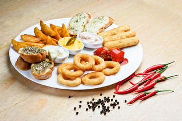 Assorted hot snacks. roasted cheese, croutons, onion rings with ketchup