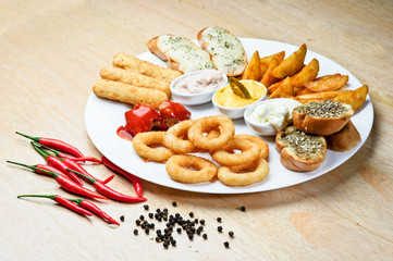 Assorted hot snacks. roasted cheese, croutons, onion rings with ketchup