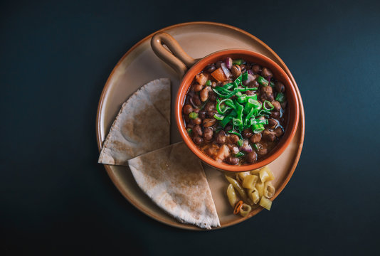 A high angle view/color studio image of Egyptian, Arabian, Middle Eastern Traditional food (Fava Beans with Vegetables/Green Paprika) A.K.A (Foul) Also served in Lebanon and most of Arabian countries.