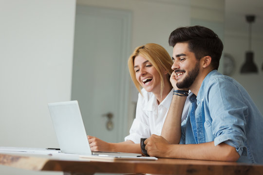 Handsome Young Man And Attractive Woman Working On Laptop