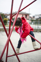 5 year old girl climbs on an iron structure