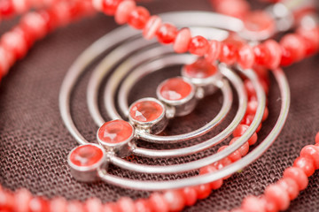 Serdolik (carnelian) stone necklace laying on natural brown linen tablecloth. Yashma, orange jasper, onyx gemstones around. Healing, powerful energy for crystal therapy treatments. Esoteric background