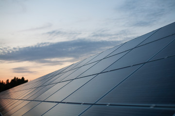 Fototapeta na wymiar Ground mounted solar panels with a sunset backdrop