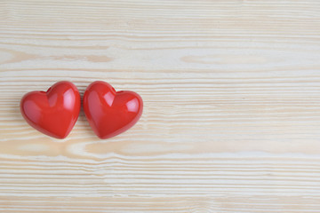Two Red hearts on wooden background.