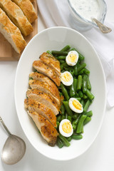 Roasted chicken breasts served with fried egg and boiled green beans.