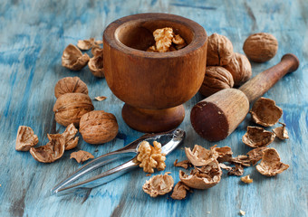 Fresh walnuts and mortar on a blue wooden table