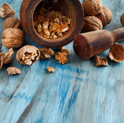 Fresh walnuts and mortar on a blue wooden table