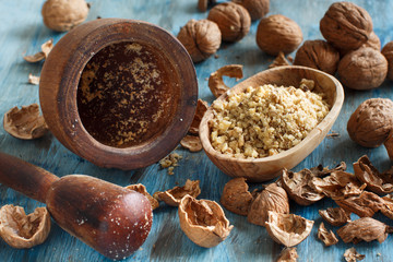 Fresh walnuts and mortar on a blue wooden table