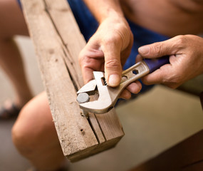 The man unscrews the bolt with a key