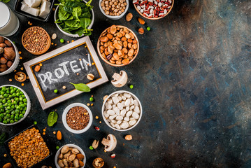 Healthy diet vegan food, veggie protein sources: Tofu, vegan milk, beans, lentils, nuts, soy milk, spinach and seeds. Top view on white table.