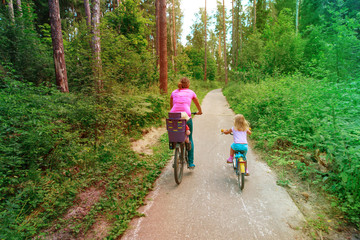 Obraz premium mother with kids riding bikes in summer nature