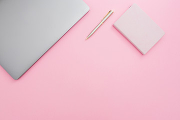 Beauty office desk with laptop, notebook and pen on pastel pink background. Top view. Flat lay lifestyle concept.