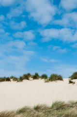 Looking up a sand dune at a blue sky in Northern France