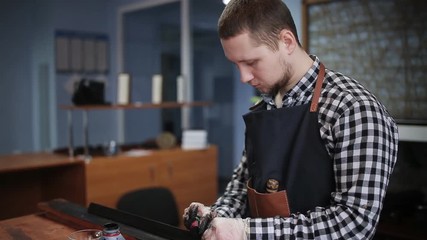 Leather handbag craftsman at work in a workshop