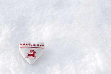 White heart with winter cross stitch deer in red on snow. Scandinavian Norwegian styled Christmas stitching on snowflakes