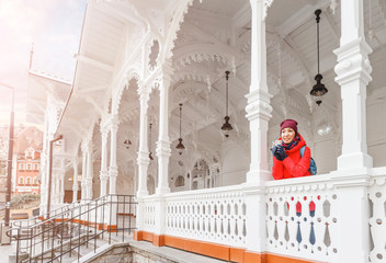 Woman tourist in red jacket at The Market Colonnade with its white structure in Karlovy Vary