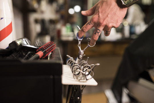  Close up detail of baber scissors and tattoo. Modern hairdressing.