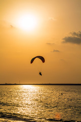 Paraglider flying over sea.Paraglider flies colorful paraglider in the blue sky.
