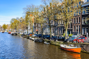 Fototapeta na wymiar Boats and boathouses in Canals of Amsterdam, Holland
