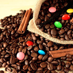 Coffee beans, multicoloured drops, cinnamon and vanilla. Ingredients for making a drink