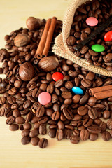 Coffee beans, multicoloured drops, cinnamon and vanilla. Ingredients for making a drink