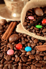 Coffee beans, multicoloured drops, cinnamon and vanilla. Ingredients for making a drink