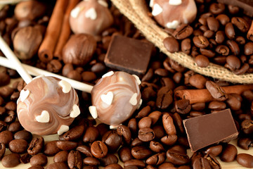 Cake pops with coffee glazing, coffee beans, chocolate pieces and cinnamon sticks
