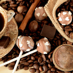 Cake pops with coffee glazing, coffee beans, chocolate pieces and cinnamon sticks