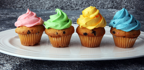 Tasty cupcakes on grey background. Birthday cupcake in rainbow colors