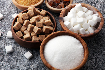 Various types of sugar, brown sugar and white on grey table