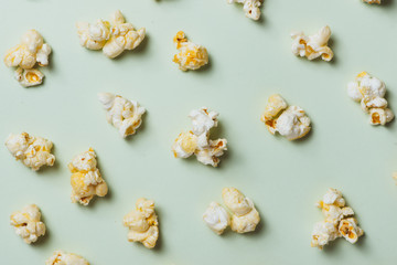 The popcorn in paper cup on green background.