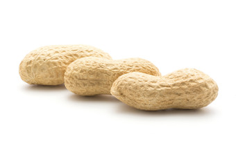 Unshelled peanuts isolated on white background three raw in row.
