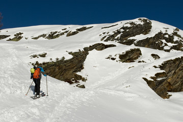 Concept: skier practice ski mountaineering, alta mountains, walking in snow, alone man, adventurous, dangerous sport, climb mountain, technical equipment, having fun in powder, sun, winter, Swiss