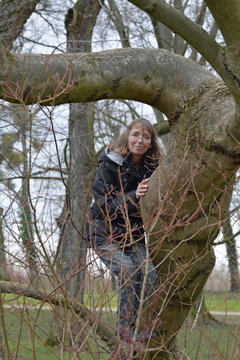 frau turnt an einem baum im park