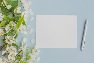 Mockup white greeting card with white spring flowers