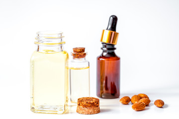 cosmetic almond oil in glass bottle on white background